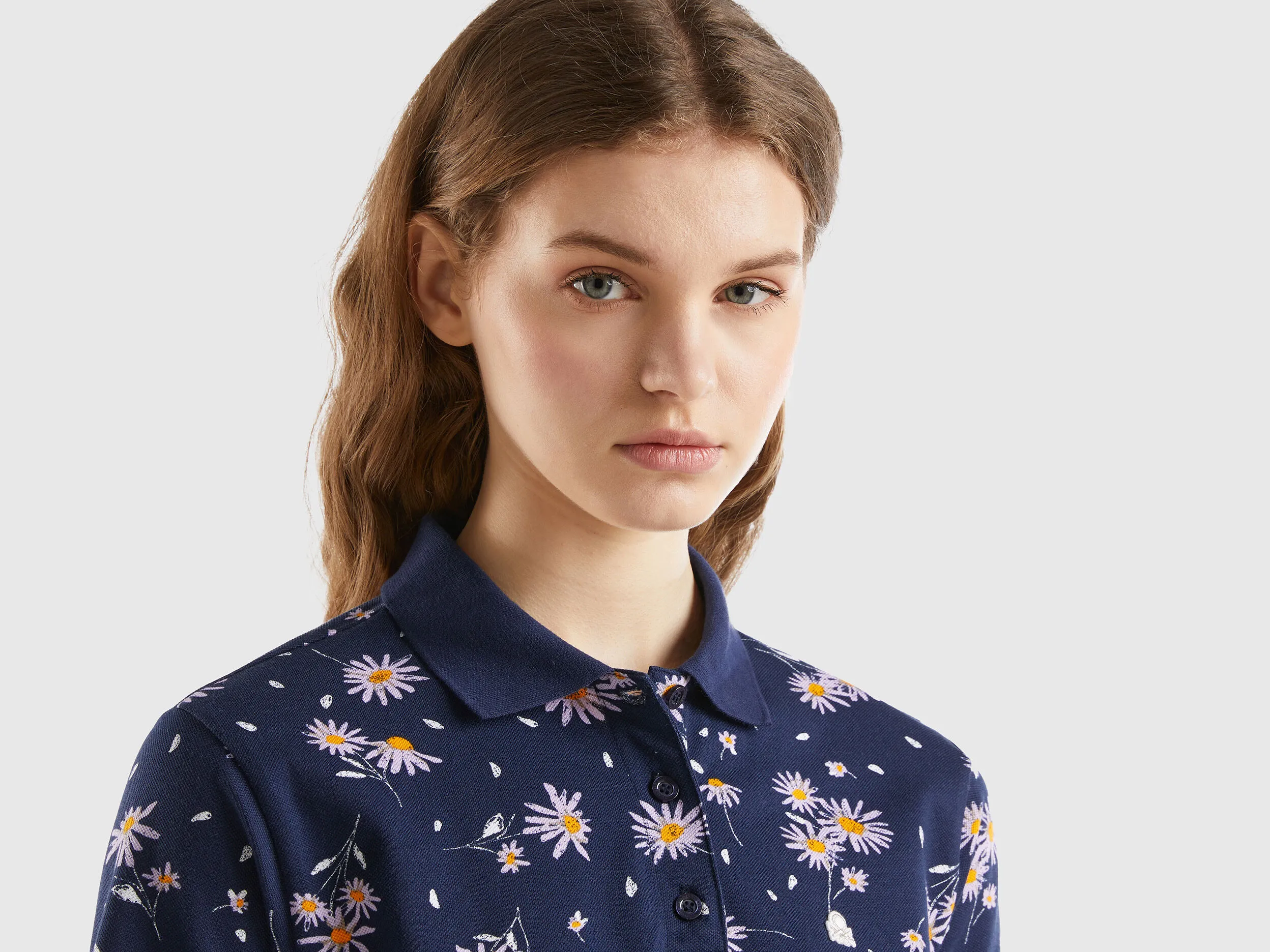 Polo azul oscuro con estampado de margaritas